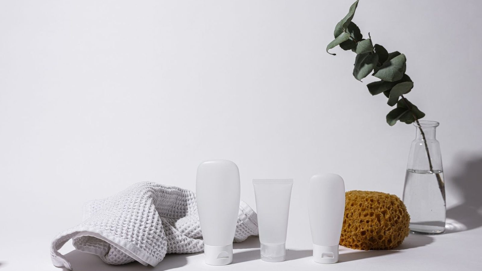 Still life of medical-grade skincare bottles and tubes on a clean neutral surface